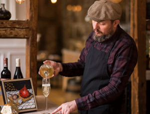 Stemningsbillede fra Restaurant Unico, hvor køkkenchef Anders hælder bobler i glas