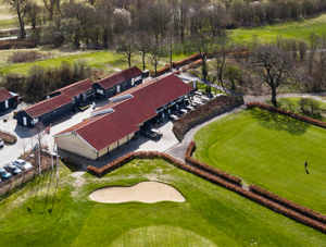 Dronefoto over Restaurant Unico og Århus Golf baner en solrig efterårsdag