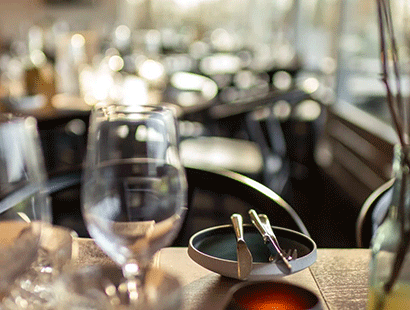Stemningsbillede fra Restaurant Unico med vinglas og tallerken